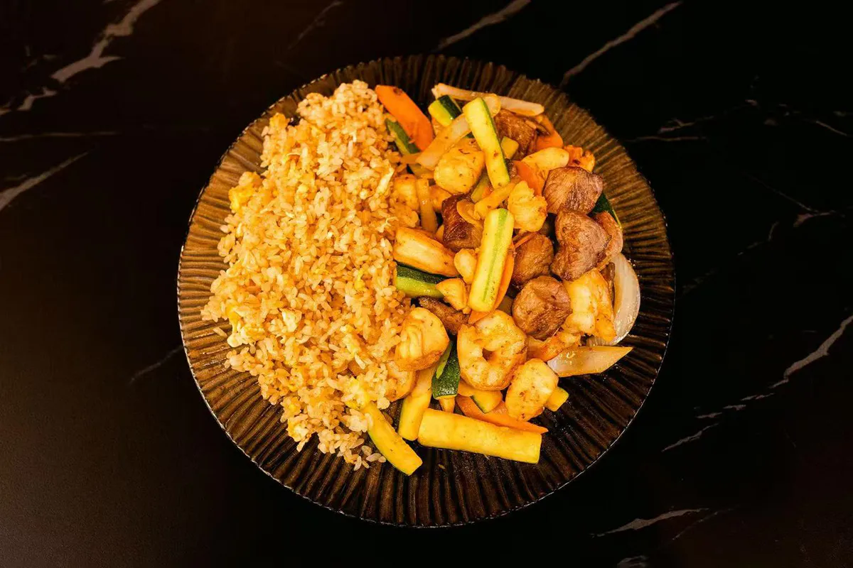 Grilled chicken, steak, and shrimp served with mushrooms, zucchini, carrots, onions and fried rice at Oishii Express, a Japanese Restaurant in Oklahoma City
